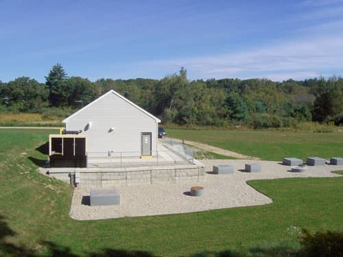 Completed pump station building with finished grading and landscaping