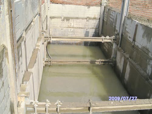 Concrete wet well structure under construction with gates installed